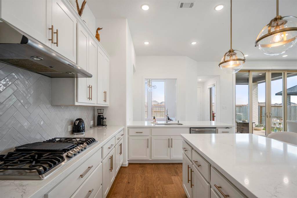 You will love the details of this kitchen! It features upgraded quartz countertops, textured white tiled backsplash, crown molding, recessed lighting, and plenty of countertop space!