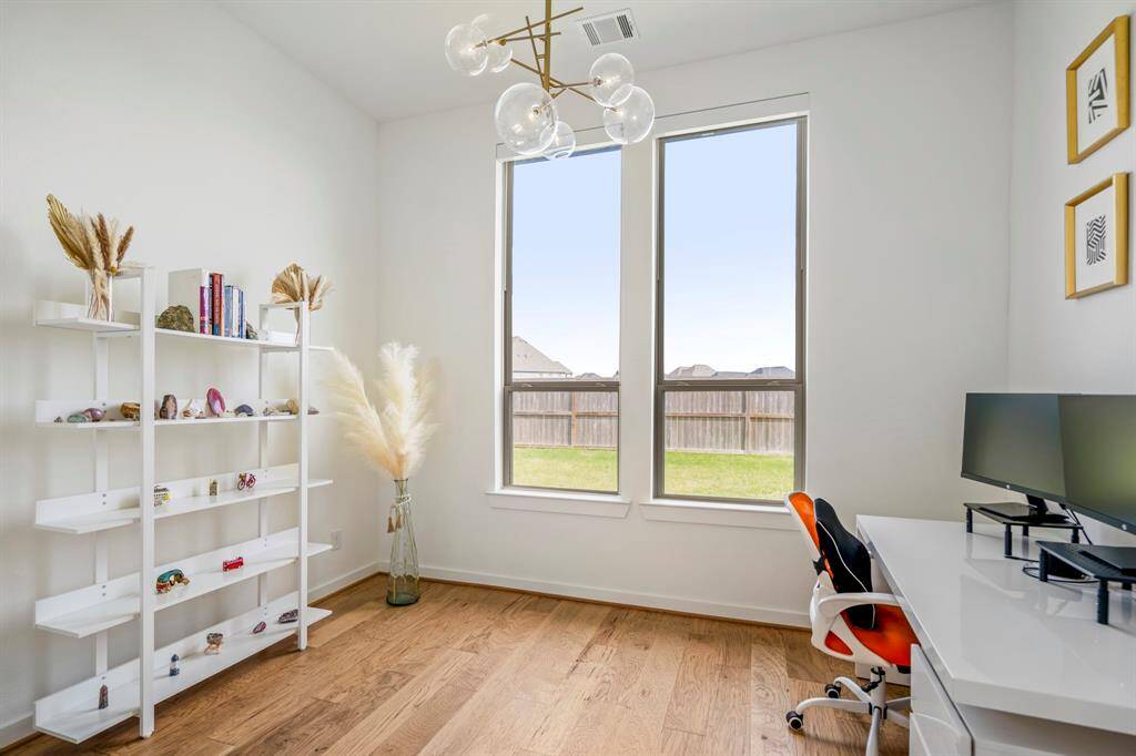 Enjoy working from home in this office space that's quietly tucked away at the back of the home giving additional serenity plus a peaceful view of the backyard! Featuring high ceilings, modern chandelier, bright natural light, wood flooring, and double door entry.