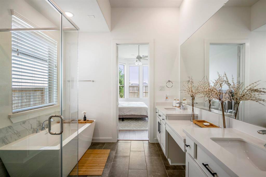 You'll love getting ready in this light and bright primary bathroom! The primary bathroom includes a large vanity with dual sinks, a make-up vanity, and a large window letting in bright natural light.