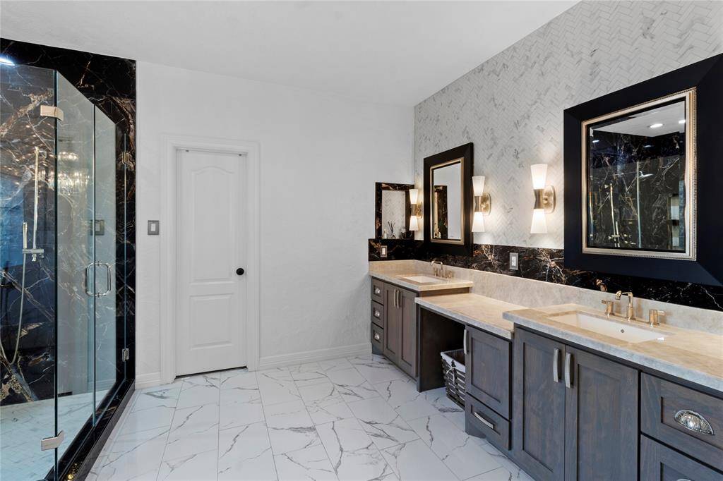 Luxurious en-suite primary bath featuring premium marble flooring and custom shower