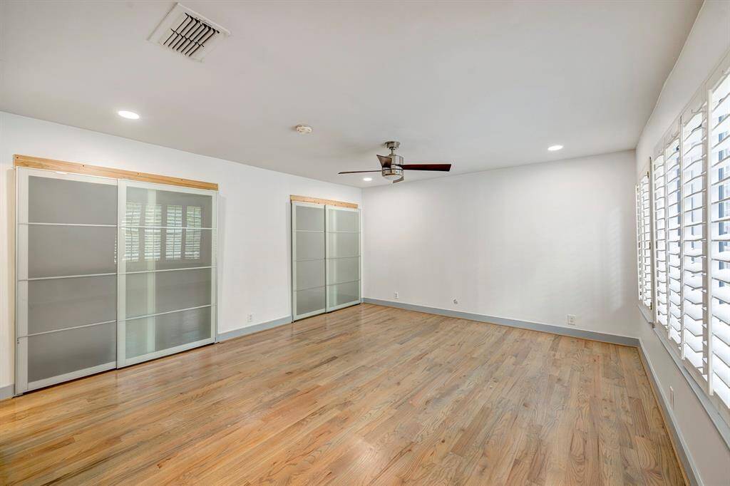 Primary bedroom has two closets with sliding glass doors.