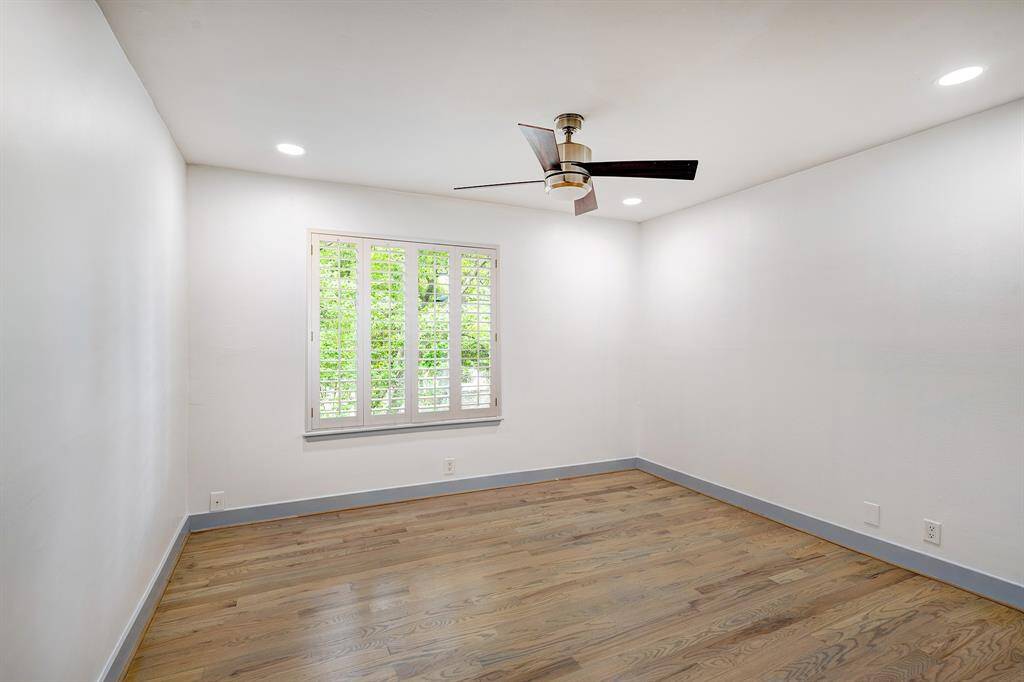 Secondary bedroom has hardwood floors, plantation shutters, ceiling fan, recessed lighting and generous closet.