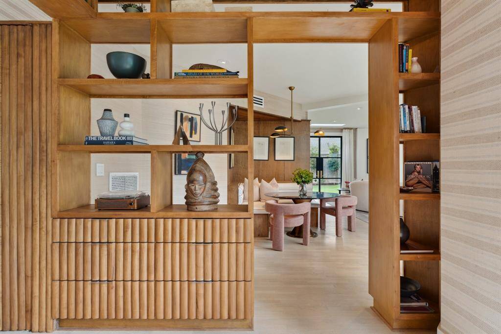 A picturesque entrance into the adjacent breakfast nook. The gallery continues with maple wood display shelves and storage drawers.
