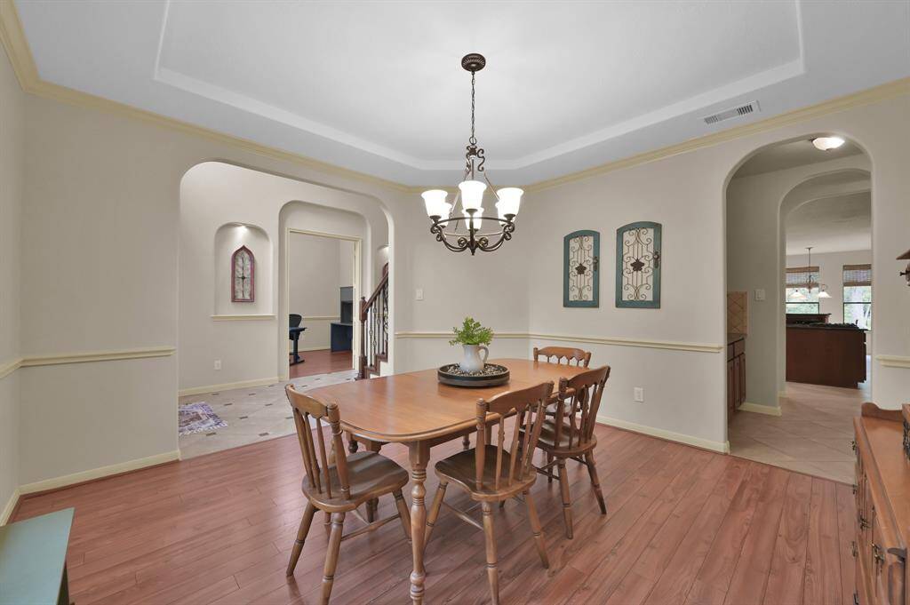 A spacious formal Dining Room at the front of the home is just off the Foyer and the Kitchen. With laminate wood flooring, tray ceiling and crown molding, it's the perfect place for hosting a large gathering. This room could also be used for an additional living space or a second office instead. It has beautiful views of the front yard.
