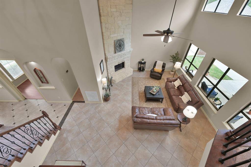 A Juliet balcony at the top of the stairs adds interest to the upstairs from the two story Living Room.