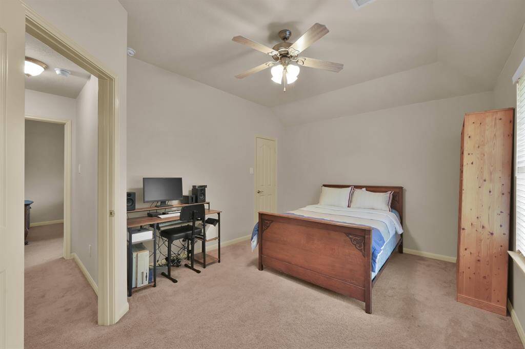 This is one of the Secondary Bedrooms at the front of the home. It has a walk-in closet, ceiling fan with light and large window overlooking the front yard. It connect to a Hollywood Bath.