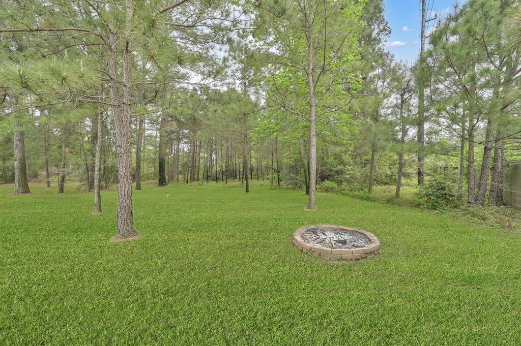 Set back in the wooded yard is a brick firepit. Add some chairs and you're ready for making memories roasting marshmallows with family and friends. To the far right is a shed to store additional yard items.