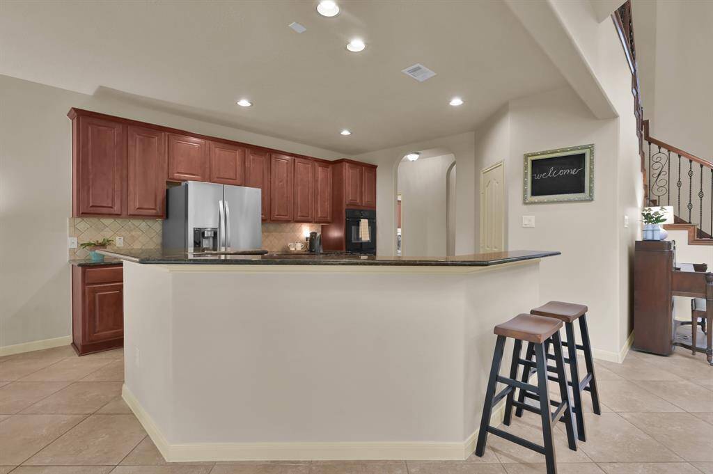 The Kitchen is equipped with 42" raised-panel Cherry cabinets and granite countertops with extra bar seating or a great place to place food items while entertaining. Since the Kitchen is open to the Living Room, whoever is cooking can still feel part of the group.