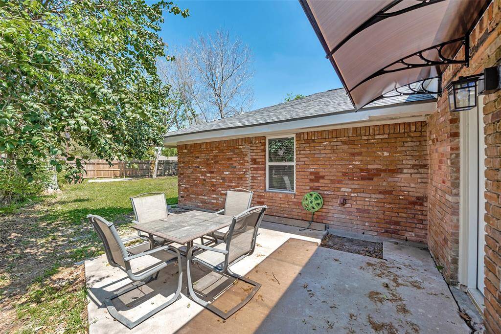 This photo showcases a single-story home with a new roof, attached garage, and a spacious front yard featuring a mature tree. The driveway and sidewalk are well-maintained, providing a welcoming entrance.