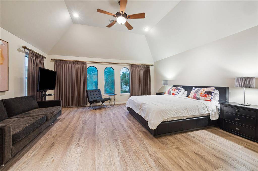 The large Primary Bedroom [18x 17] is located on the second floor and features new hardwood floors (2021), a vaulted ceiling, space for additional sitting area, arched windows overlooking the front yard and an en-suite bathroom.