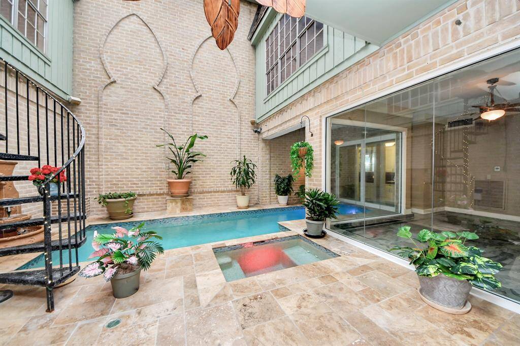 Pool has separate hot tub perfect for entertaining or time alone. Fountains and plants create oasis vibe