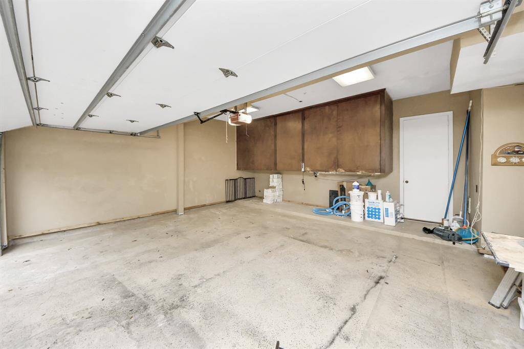 Oversized two car garage has huge storage cabinets for equipment or enough room to leave it out