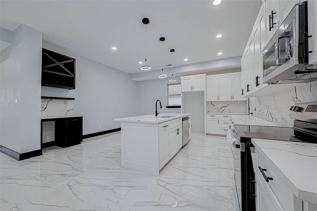 Enjoy the sleek modern kitchen with quartz countertops and cabinets that close softly. Cook with ease on the electric stove.