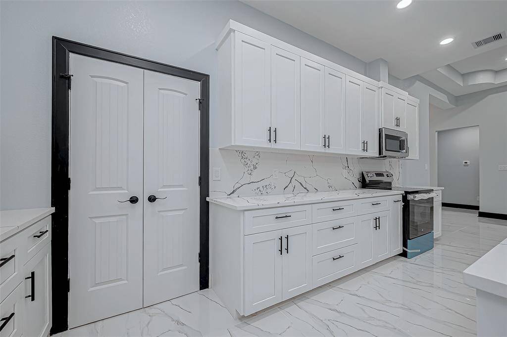 A pantry with elegant French doors adds both style and functionality, providing ample storage while enhancing the kitchen's charm.