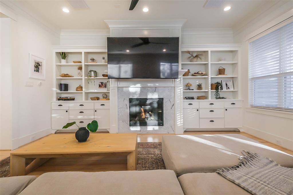 The photo showcases a modern fireplace and high ceilings.