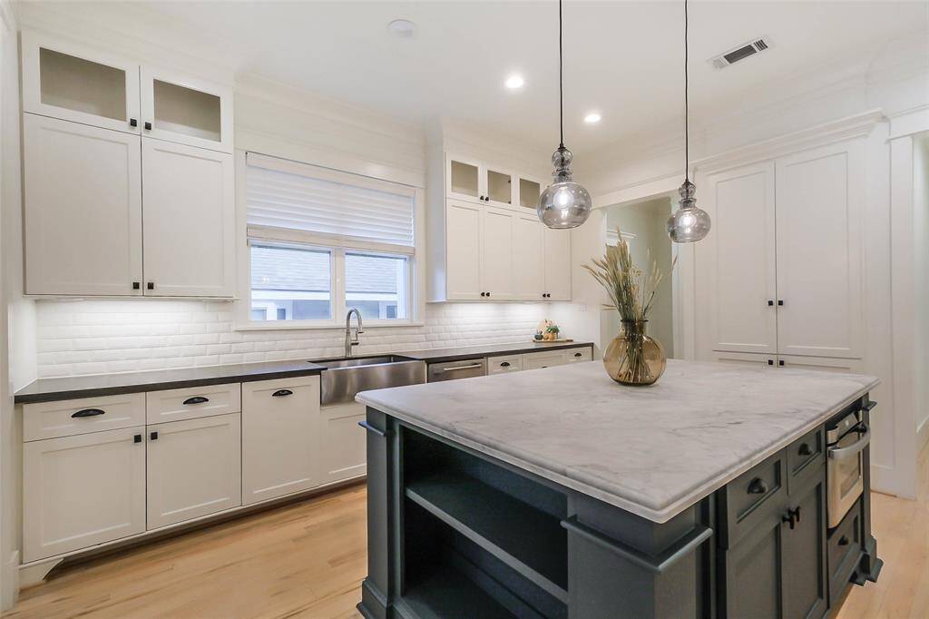 Beautiful farmhouse sink, and sleek countertops. It includes a large central island withpendant lighting, providing a stylish focal point and ample space.