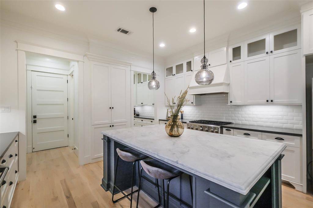 The space is bright and inviting, with stainless steel appliances and a sleek white subway tile backsplash.