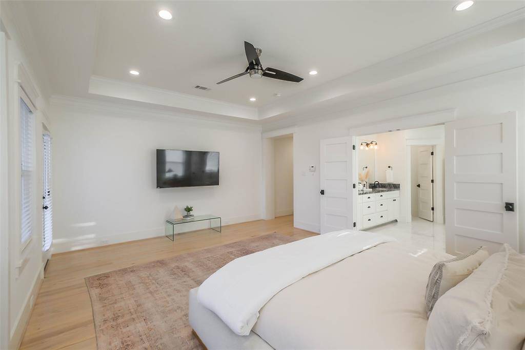 The Primary bedroom connects to an en-suite bathroom with dual sinks and black fixtures and hardware.