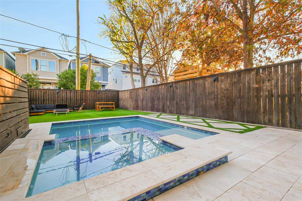 The pool has beautiful stone decking and has a perfectly manicured backyard.