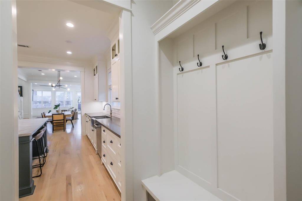 Mud room is conveniently located in the hallway leading to the garage with coat hooks and space for storage.