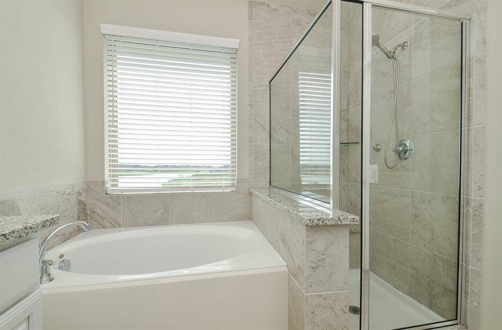 neutral colors are featured in this room primary bathroom with separate shower