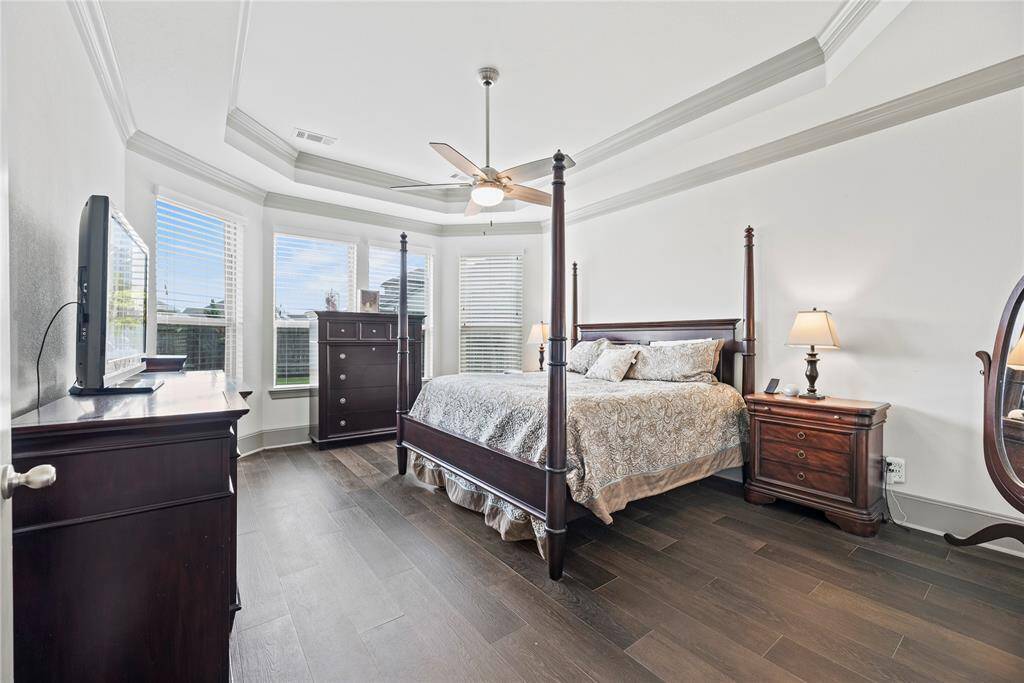 Generously sized primary suite with vinyl flooring and a beautiful ceiling.