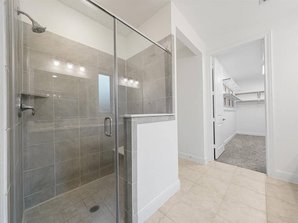 Walk-in tiled shower with built-in shower seat.