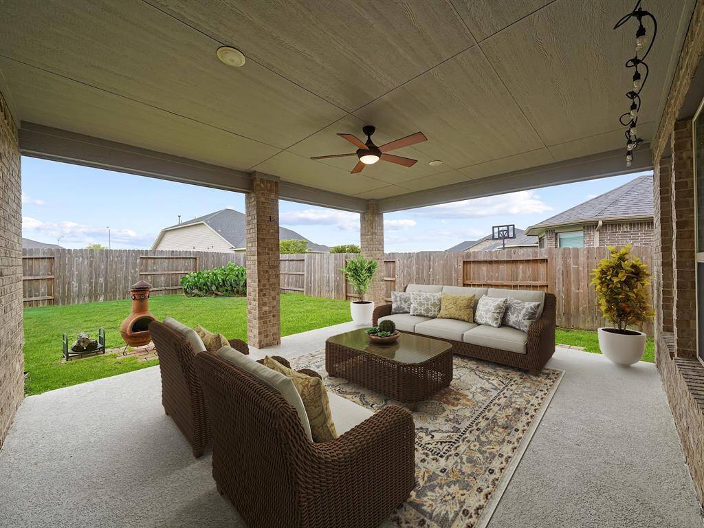 **Virtually Staged**Covered patio with ceiling fan... retreat from the Texas heat. Add an outdoor kitchen or grill and this is the perfect space to host backyard barbeques.
