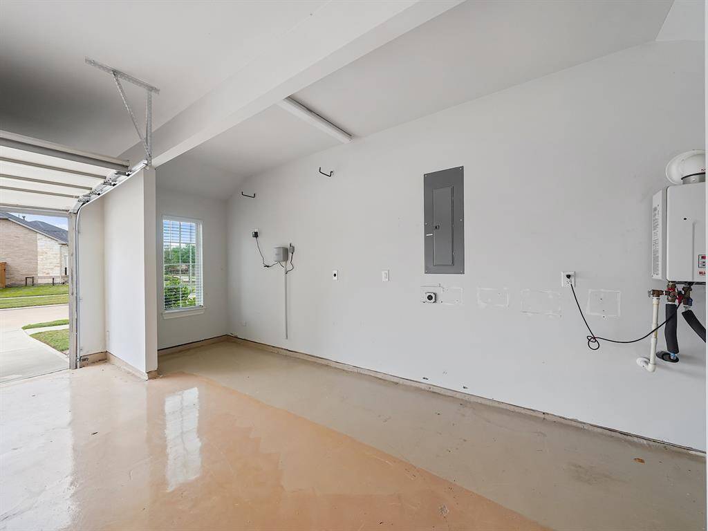 Oversized garage with epoxy flooring.  Extended area is perfect for lawn-care items and garbage/recycling bins.