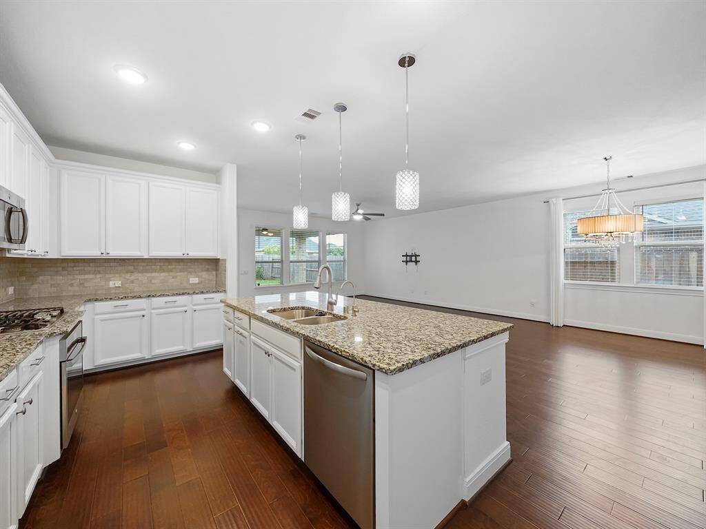 Stainless steel appliances (dishwasher, microwave, oven, and gas cooktop).
