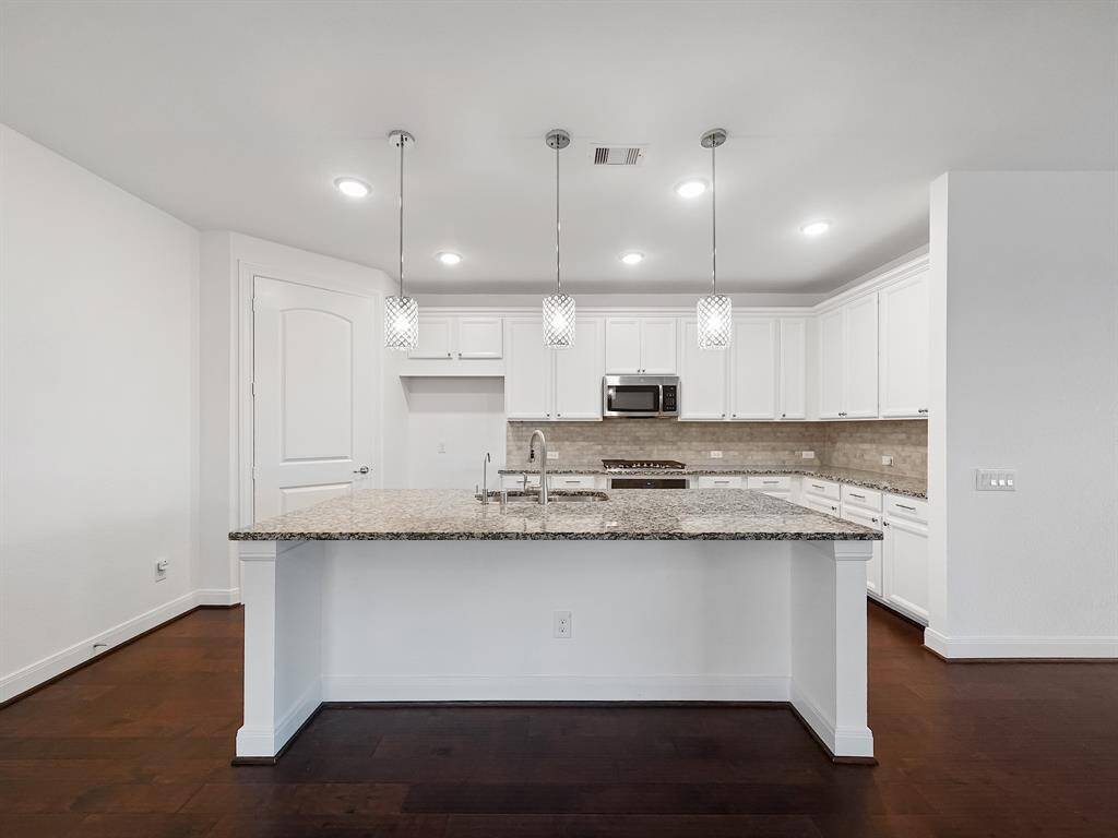 Elegant pendant lighting over the island brightens the space.