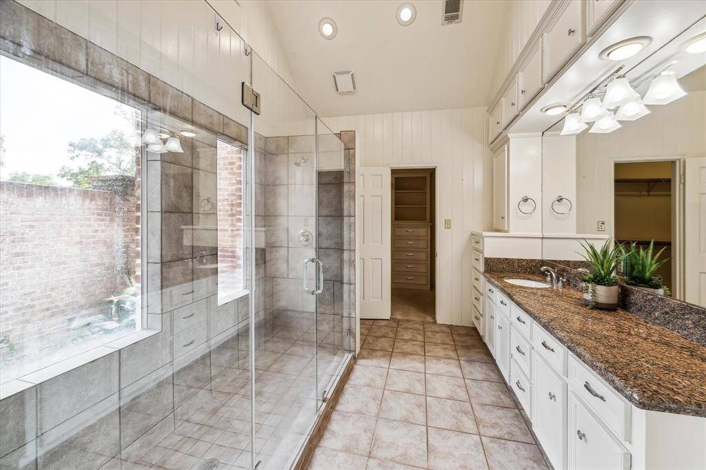 The first side of the primary bath includes an oversized walk in shower and extended vanity.