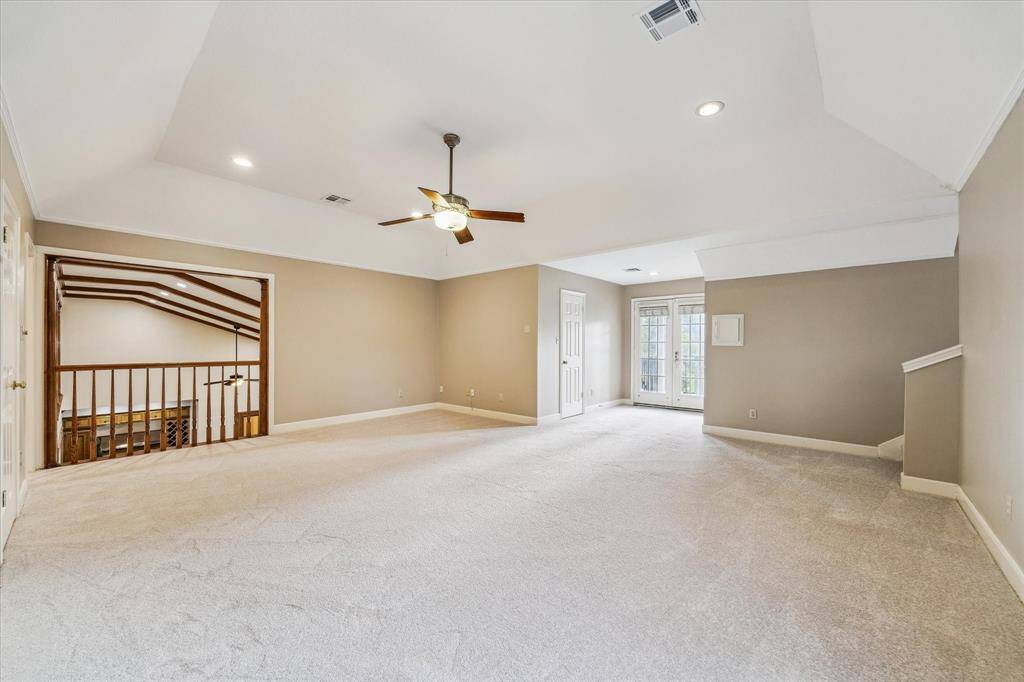 An oversized game room overlooks the family room and accesses the guest quarters. It extends to a balcony with stairs to the backyard.