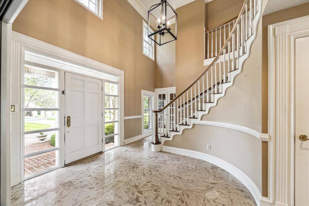 Marble tile and a sweeping staircase envelope this grand entry.