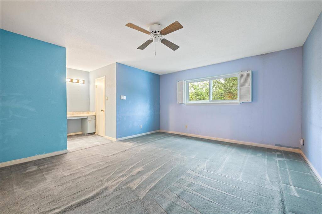 Primary bedroom with a vanity area and walk-in closet. This could be reconfigured for an amazing bathroom.