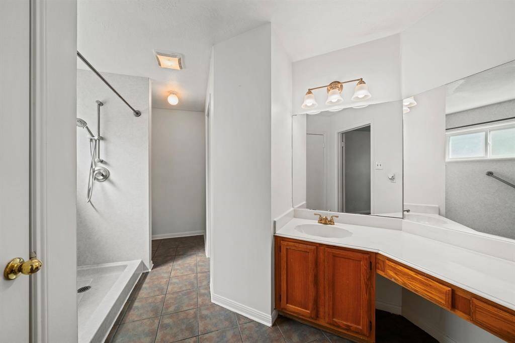The primary bathroom offers a good amount of countertop space, upgraded shower and walk-in closet.