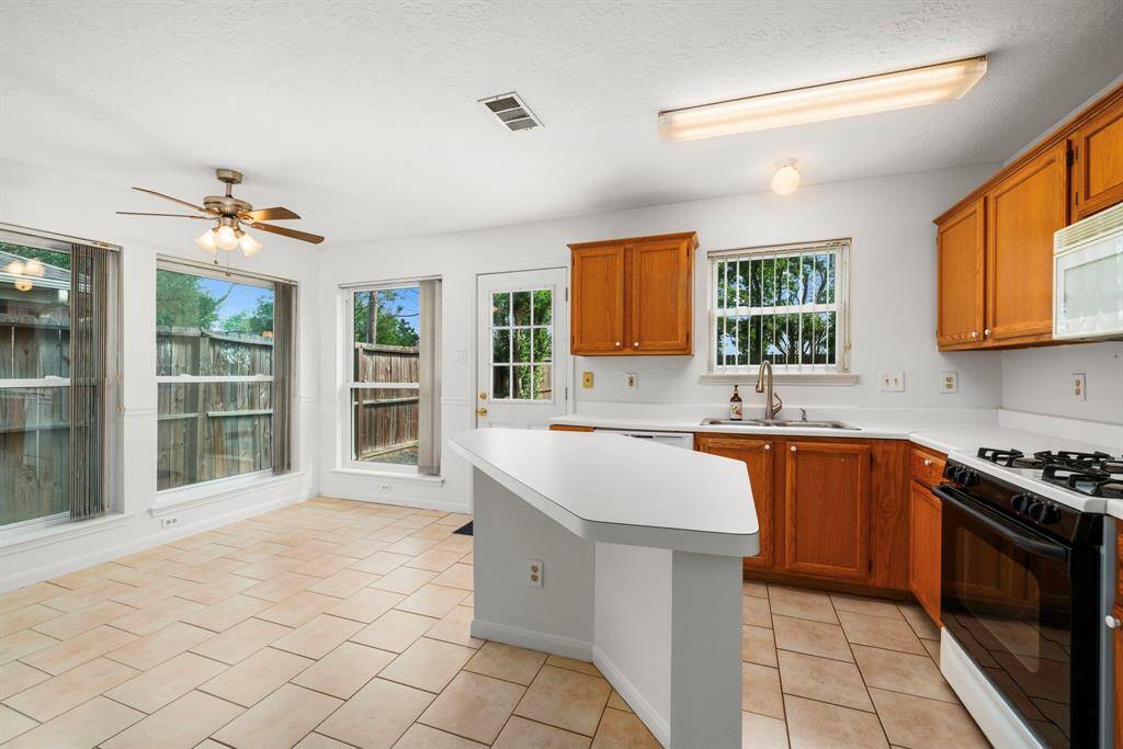 The kitchen offers gas cooking, solid surface countertops and a breakfast area that can accommodate a sizable table. Notice the amount of windows in this room, as well!