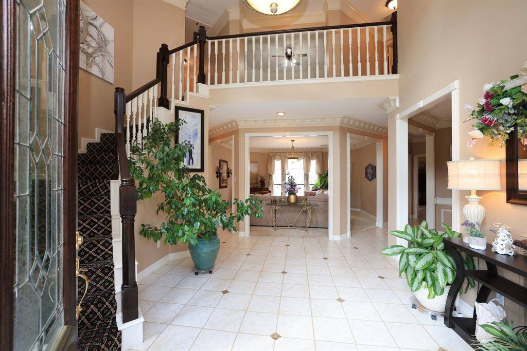Grand entrance with cascading stairwell to the left and cat walk above the living area.