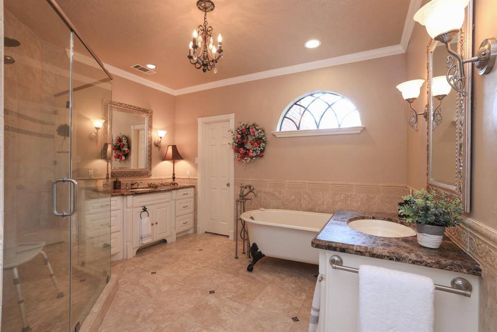 This Primary bath is stunning with Emperador marble countertops and undermounted sinks.  A claw footed tub is the piece de resistance!