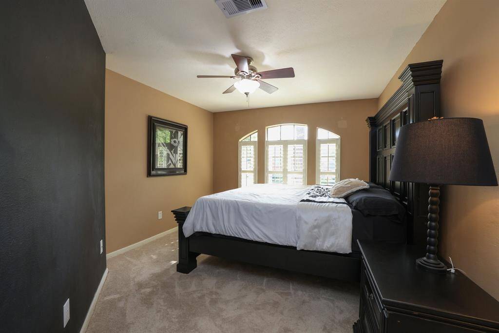 Secondary bedroom at the top of the stairs features arched window facing the front yard.