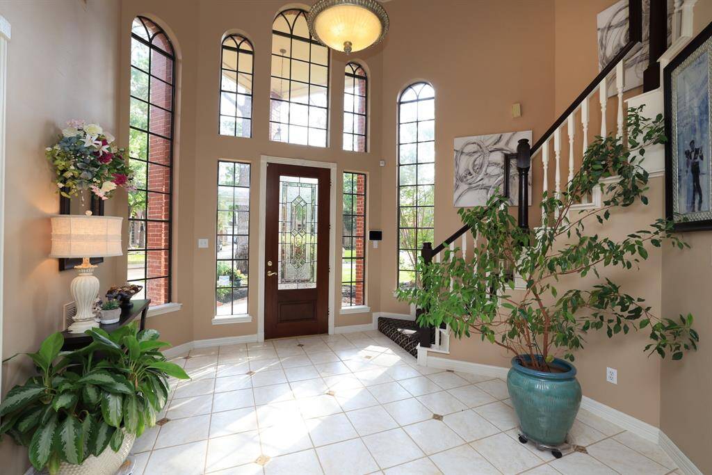 Two story foyer with side lights and second story windows with lots of natural light.