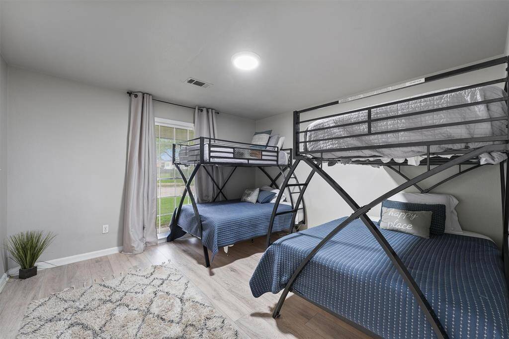 This spacious bedroom easily accommodates multiple beds, making it ideal for guests or a fun kids’ retreat.