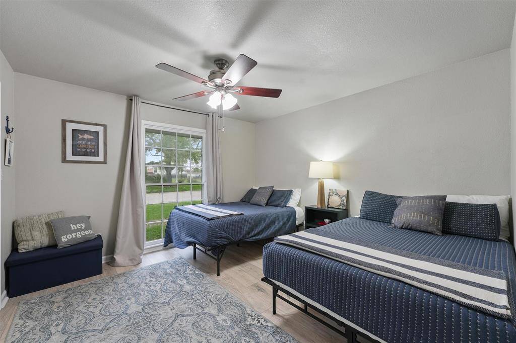 This generously sized bedroom features two beds and a cozy sitting nook, perfect for visitors or family.
