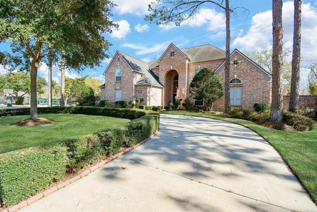 The Curved Driveway adds Elegance this Stunning Brick Home which features a Grand Entrance with a Two-Story Arched Entryway.