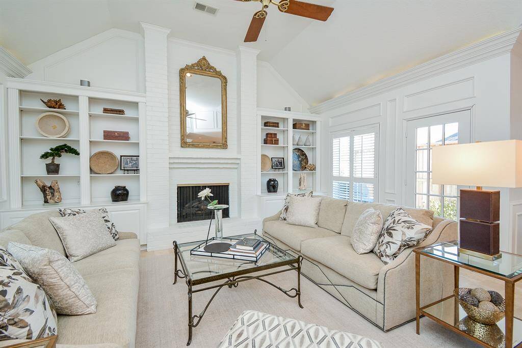 Bright and spacious Den with High ceilings, Backlit Crown Molding Cozy Fireplace, Built-In shelves, and Plantation Shutters.