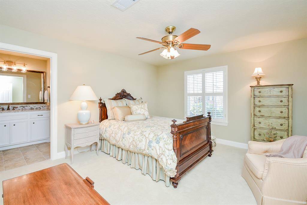 This elegant living room features a grand, open space with a high ceiling and large windows that flood the area with natural light which creates a sophisticated and welcoming atmosphere.