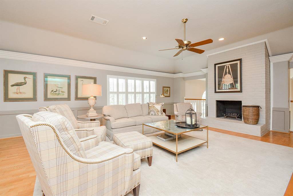 A peek into the elegant living space, The open layout includes a sweeping staircase and an upper-level balcony, enhancing the spacious feel.