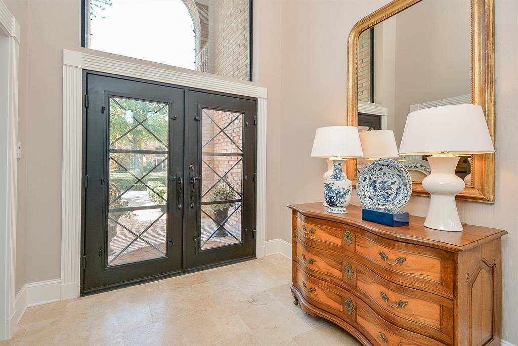 This Impressive Two-Story Entryway features High Ceilings and a Large Arched Window providing Lots of natural Light.