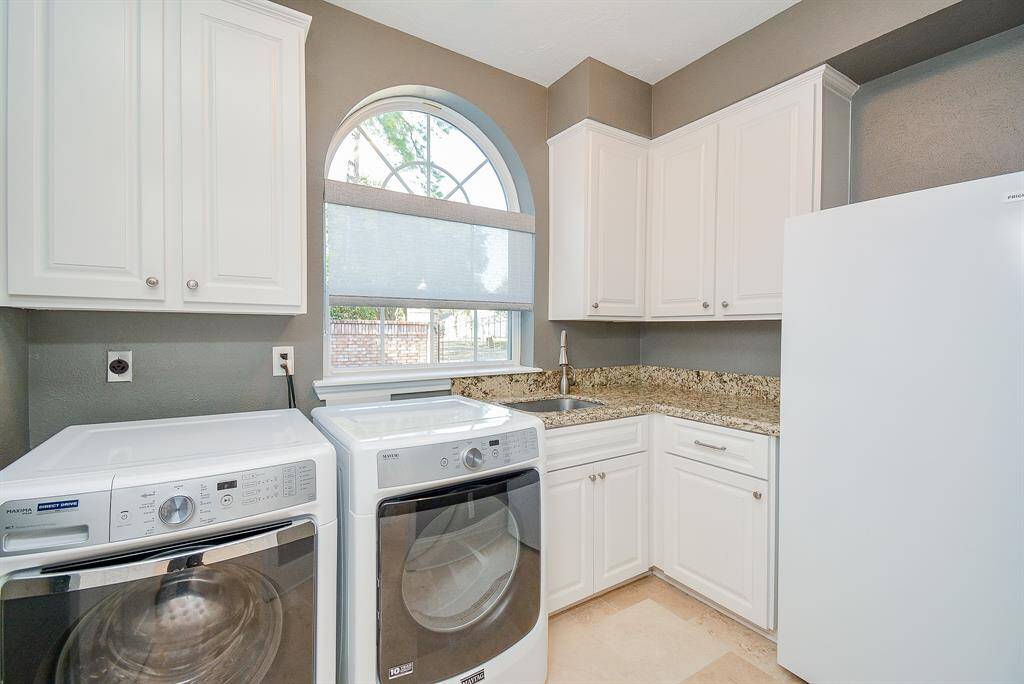 This photo showcases the spacious three-car garage and a large driveway offering plenty of parking.
