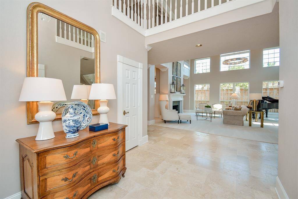 This elegant home office features ample Natural Light from a Large Window with Sheer Curtains, and Sophisticated Paneling, Ceiling Fan, and Stylish Wood Flooring creating an inviting atmosphere, perfect for productivity.